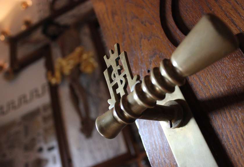 Kljuka s Kristusovim monogramom na vratih kapele v Frančiškanskem samostanu v Kamniku
