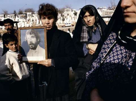 Photographs of 20 year old Kamaran Abdullah Saber are held by his family at Saiwan Hill cemetery. He was killed in July 1991 during a student demonstration against Saddam Hussein, Kurdistan North